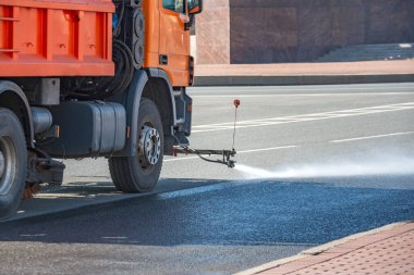 Temizlik makinesi asfalt yol yüzeyini yıkıyor. Şehir caddesi.