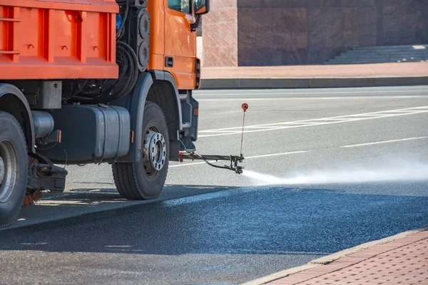 Cleaning machine washes asphalt road surface the city street