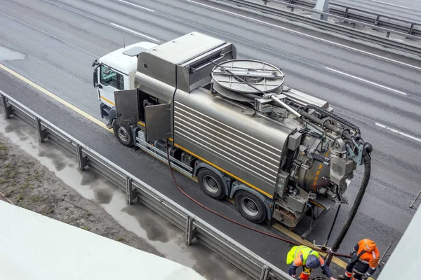 Sludge washer truck and workers specialists at work on the side of the highway to clean underground infrastructure, eliminate blockages in the sewer road sewage into the collector — Stock Image Sludge Washer Truck Workers Specialists Work Side Highway Clean Underground Royalty Free Stock Images