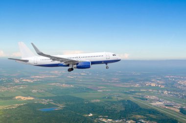 İniş takımları olan yolcu uçağı havaalanının yanından uçarak yere inmeye hazırlanıyor.