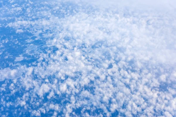 Texture of cloudy cumulus cloud fields above the earth in blue tone