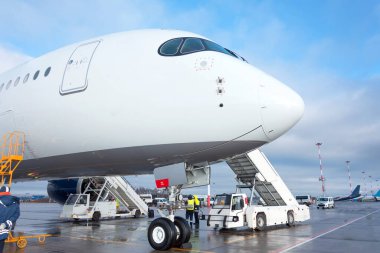 Otoparkta uçak, havaalanının açık havasında iskele, pilot kabini ile burun manzarası.