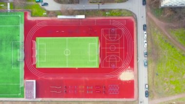 Futbol ve basketbol sahasında koşu bantları, yatay barlar ve spor sahasında diğer spor aletleri konut binalarının avlusunda.