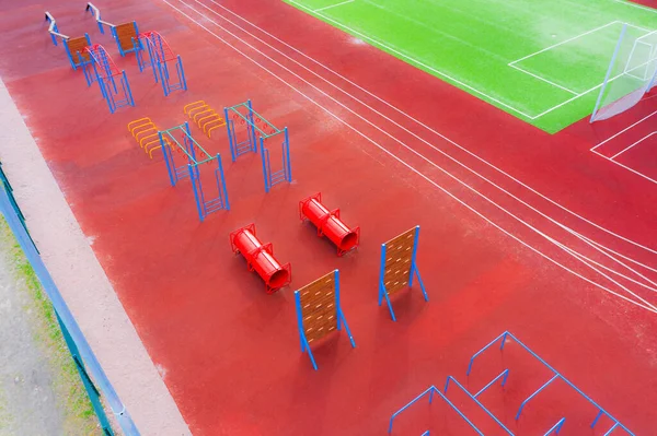 Playground with obstacle course on a sports court next to treadmills