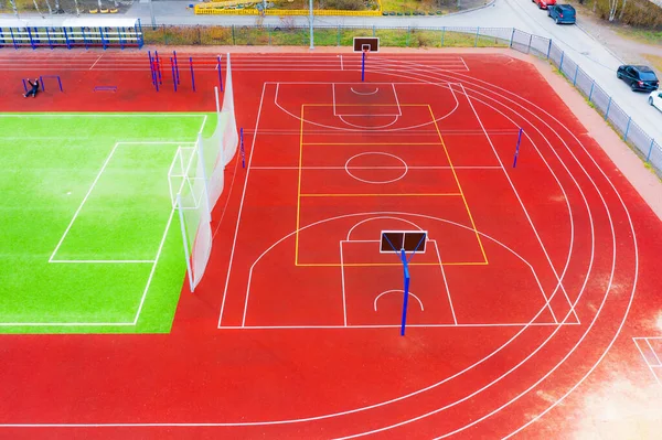 Football and basketball field with treadmills, horizontal bars and other outdoor fitness equipment on the sports ground in the courtyard of residential buildings