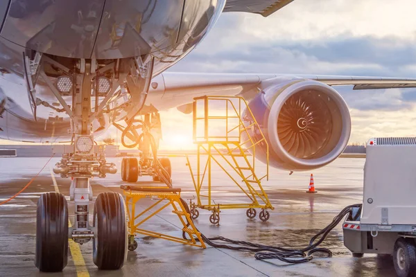 The front landing gear and auxiliary power installation to ensure autonomous power supply of the aircraft, in the background the engine. Evening sunset serviced flight