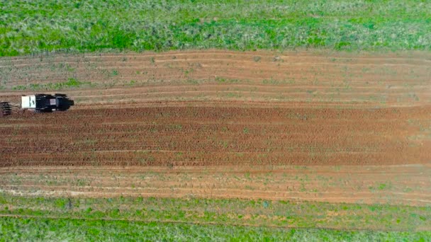 Tractor plows a small field in the village before planting vegetables. Aerial height top view — Stock Footage Tractor Plows Small Field Village Planting Vegetables Aerial Height Top Video Clip