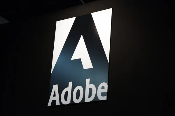 Λογότυπο Adobe και γράμματα σε μαύρο τοίχο — Φωτογραφία Αρχείου