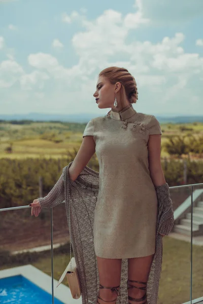 Женщина в платье стоит на балконе — стоковое фото
