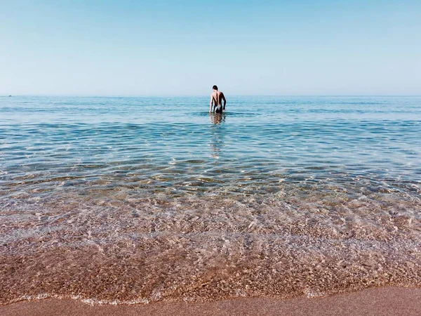 Человек, ходящий в воде — стоковое фото