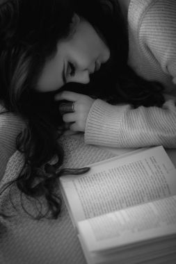 bir kitap üzerinde uyuyan kız 