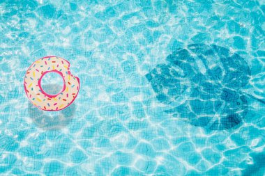 Havuzu alt şişme çörek ile üstten görünüm monstera gölgesi ile