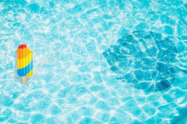 Havuzu alt şişme renkli dondurma ve monstera gölgesi ile Üstten Görünüm