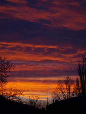 Şehirde kızıl bulutlar ve şafak vakti. Kış fotoğrafçılık.