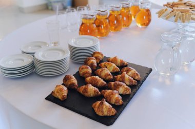 Küçük kruvasanlarla taştan bir tabak. Yemek servisi. İş yemeği..