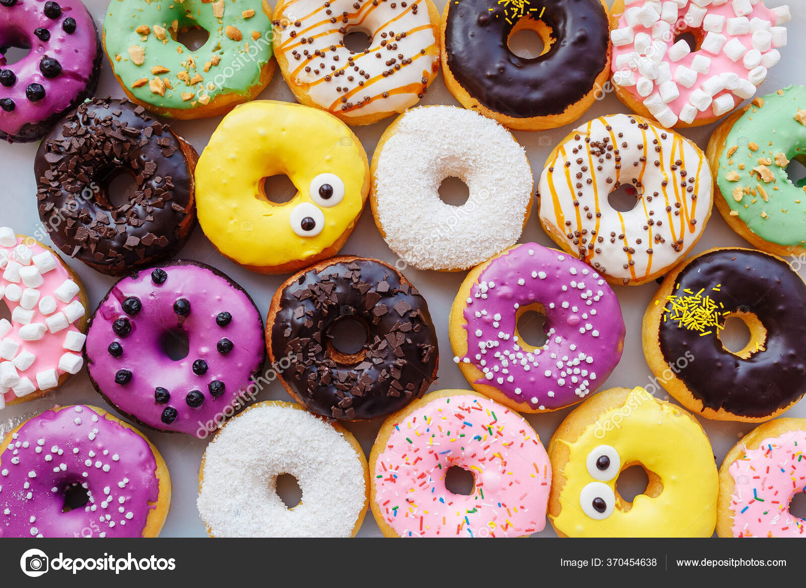 Um monte de rosquinhas multicoloridas com diferentes recheios, vista  superior — Foto © Dahin #370454638, image size:1600x1167