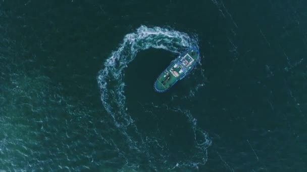 La vista superior del remolcador se mueve en un círculo creando hermosas olas circulares, el mar azul profundo — Vídeo de stock