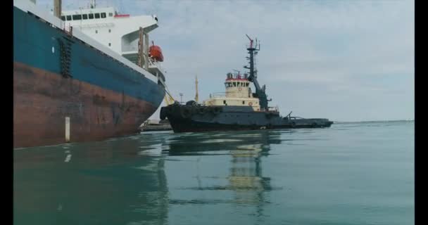 Mouvement de la caméra le long de la voie navigable, vue sur le navire. Remorqueur et côté du grand navire 