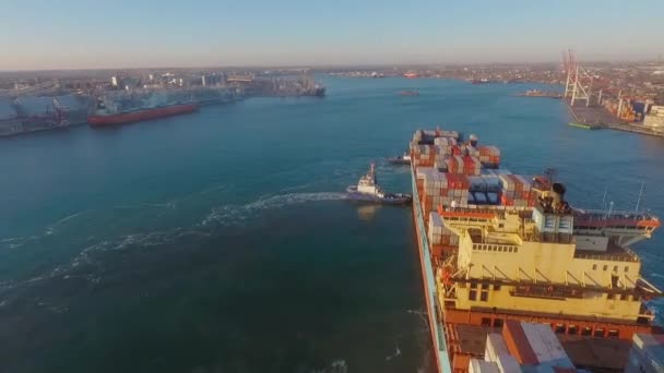 Vista panorámica del puerto con el puerto. Dos remolcadores acompañan al carguero hasta la costa. Vista superior — Vídeo de stock