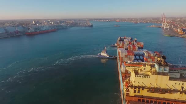 Vista panorâmica do porto com o porto. Dois rebocadores acompanham o cargueiro até a costa. Vista superior — Vídeo de Stock