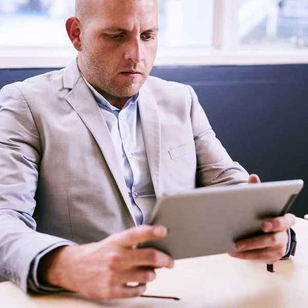 Homem de negócios segurando e usando um tablet de alta tecnologia — Fotografia de Stock