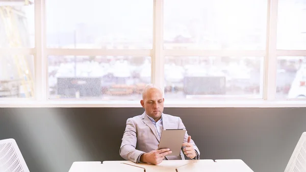 Homem de negócios segurando e usando um tablet de alta tecnologia — Fotografia de Stock