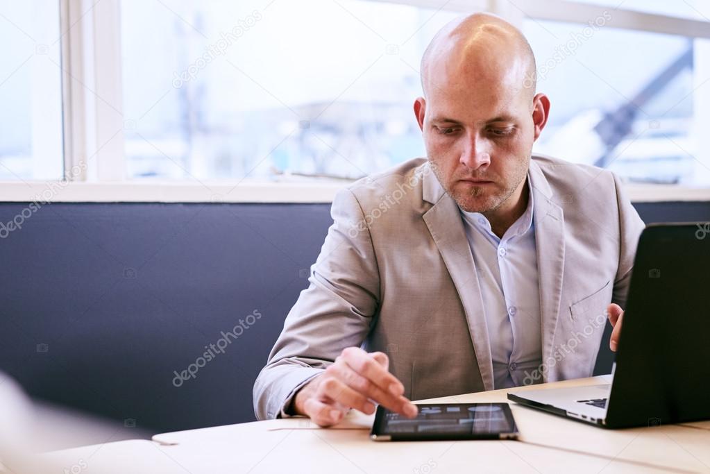 Professional business man working on his portable tablet and computer