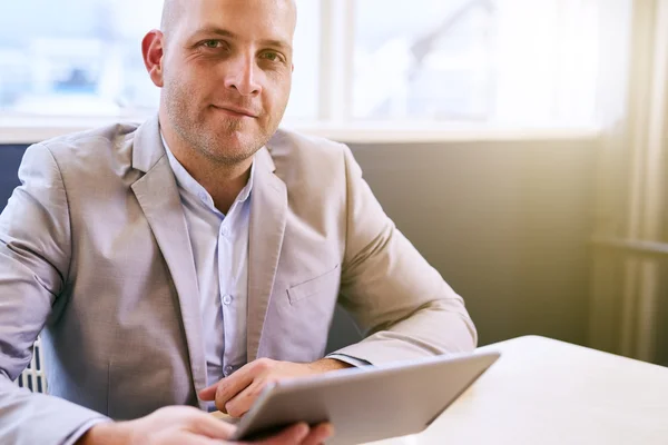 Feliz hombre de negocios sosteniendo la tableta mientras mira a la cámara — Foto de Stock