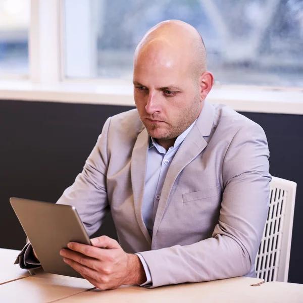 Homem de negócios segurando e usando um tablet de alta tecnologia — Fotografia de Stock