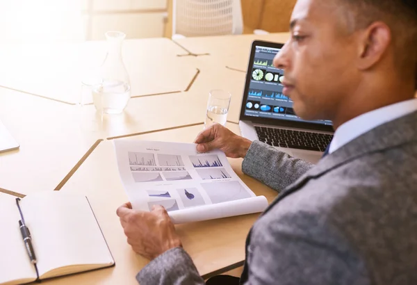 Over the shoulder image of businessman holding document with graphics — Stock fotografie