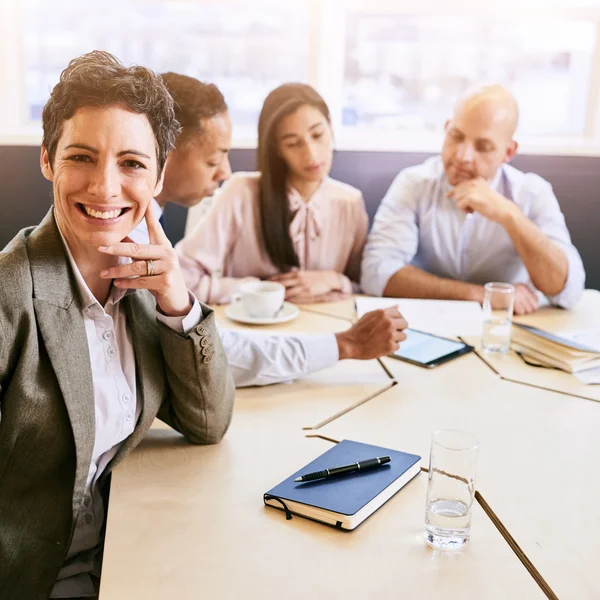 Mature businesswoman looking at the camera during business meeting — Stock Photo, Image