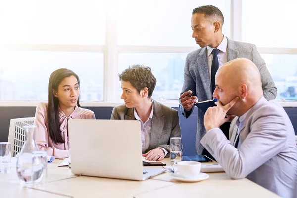 Mature businessman supervising his employees as they work — ストック写真