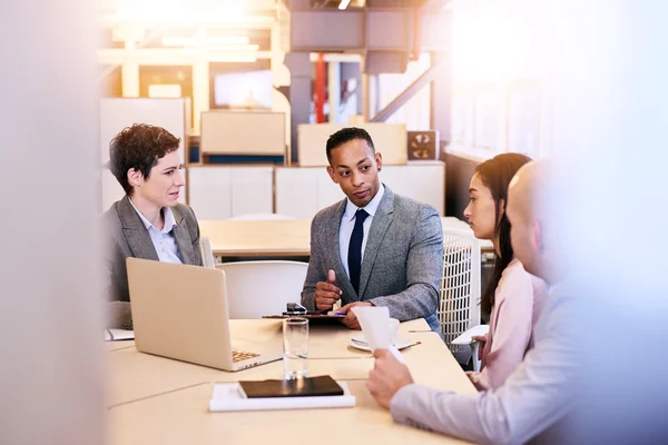 Eclectic group of four business professionals conducting a meeting — Φωτογραφία Αρχείου