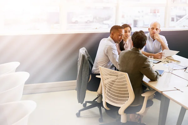 Cuatro individuos eclécticos de negocios que llevan a cabo una reunión en la sala de conferencias —  Fotos de Stock