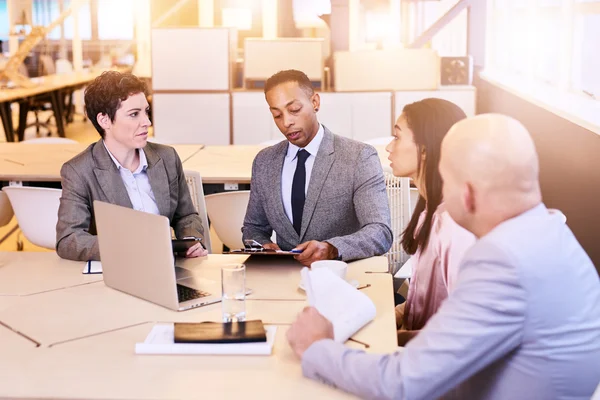 Eclectic group of four business professionals conducting a meeting — Stock Photo, Image