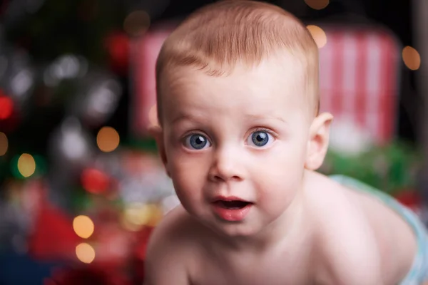 Дитина носить підгузник перед різдвяними подарунками та прикрасами — стокове фото