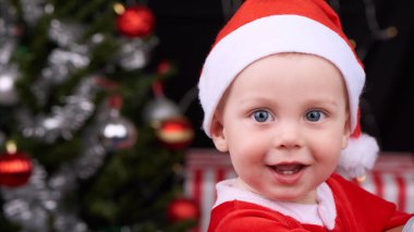 Neşeyle kamera Noel Baba kıyafeti gülümseyen erkek bebek