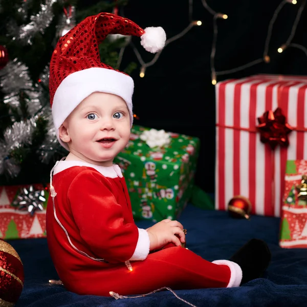 Baby in santa outfit looking over shoulder at camera — Stock Photo, Image