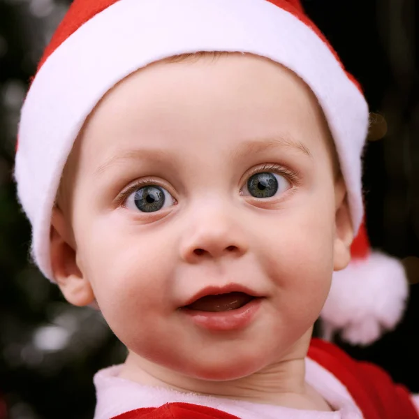 Baby boy looking into camera wearing a santa outfit — Stock Photo, Image