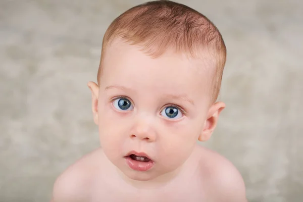 Мила біла дитина дивиться в камеру з великими блакитними очима — стокове фото
