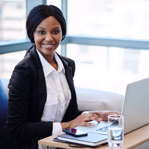 Mulher de negócios preta sorrindo para a câmera na frente do computador — Fotografia de Stock