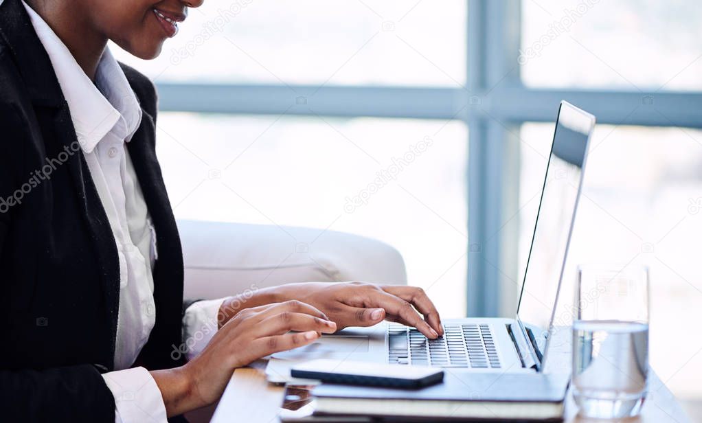 Headless crop of black businesswoman busy typing on notebook keyboard