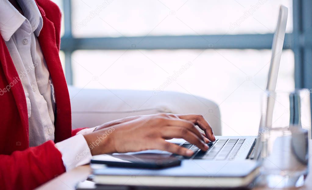 Generic image of black businesswomans hands busy typing on computer