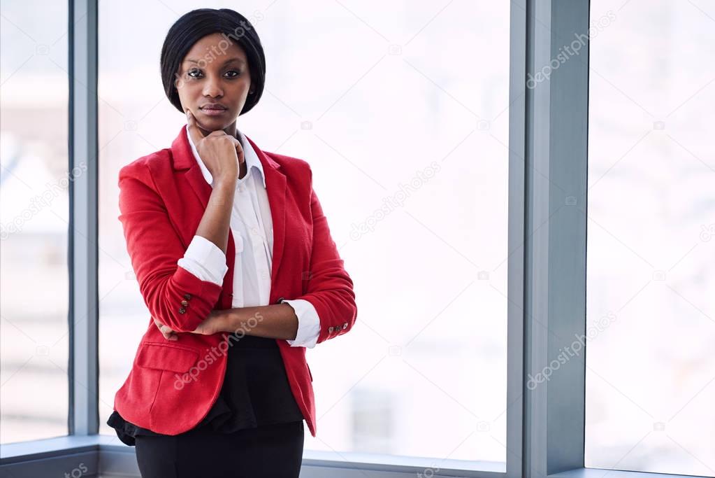 African businesswoman looking into camera confidently while wearing red blazer