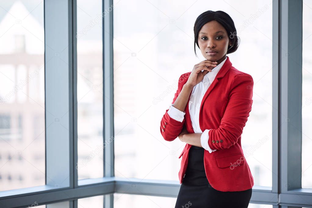 African businesswoman looking into camera confidently while wearing red blazer