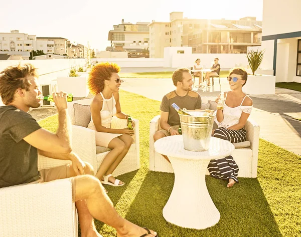 Amici che si godono la compagnia al sole con bevande — Foto Stock