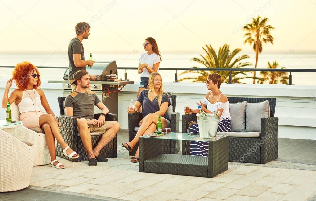 Happy group of close friends socialising together on a rooftop