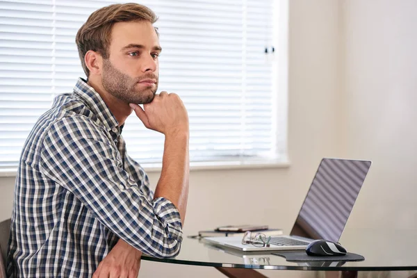 Young man looking thoughtfully into the distance, procrastinating his work — Stock Photo, Image