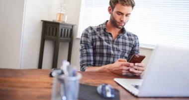 Cep telefonu kullanarak masada oturan adam