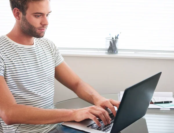 Attractive young male student working on a laprop from home — Stock Photo, Image